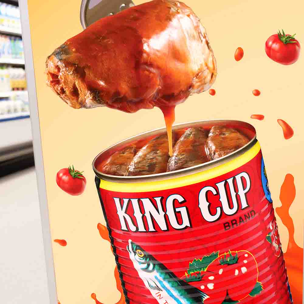 A fork takes out a piece of sardine from red KING CUP can with tomatoes and tomato sauce in the background